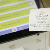 Un ticket de turno de voto por correo en la oficina de Correos de la calle Conde de Peñalver. Carlos Luján / Europa Press