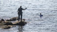 Un guardia civil avisa a una persona que nada en el mar. Marcos Moreno / Europa Press