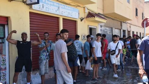 Varias personas hacen cola en un punto de atención humanitaria en Ceuta. Gabriela Sardá Núñez / Europa Press
