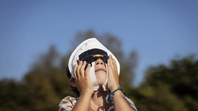 Un niño durante el eclipse solar total de 2026, a 12 de agosto de 2026, en Lugo, Galicia. Agostime / Europa Press
