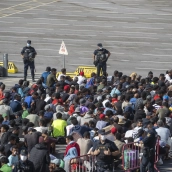 Migrantes desalojados de la playa del Trampolín de camino a ser reubicados, a 20 de agosto de 2026, en Ceuta. Marcos Moreno / Europa Press