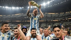 Lionel Messi celebrates with the FIFA World Cup trophy atop of Sergio Aguero s shoulders