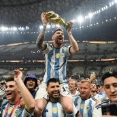 Lionel Messi celebrates with the FIFA World Cup trophy atop of Sergio Aguero s shoulders