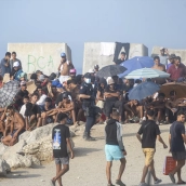 Decenas de migrantes en la playa de El Trampolín, Ceuta, este lunes. Marcos Moreno / Europa Press