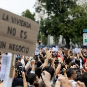 Numerosas personas sostienen una pancarta con lema 'La vivienda no es un negocio' en Madrid