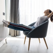 Mujer relajada disfrutando del calor de su radiador.