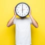 handsome man white t shirt transperent glasses hold big clock place his head