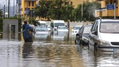 Un hombre atraviesa con un perro una zona inundada en Guardamar de la Safor, Valencia. Fuente: Rober Solsona / Europa Press.