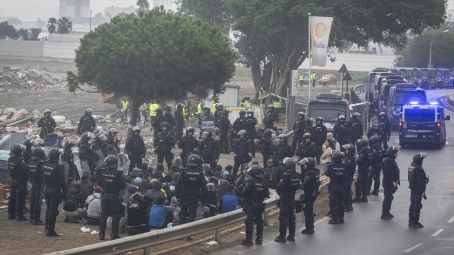 Agentes de la Policía Nacional intervienen durante el proceso de desalojo del embolsamiento de migrantes en la playa de El Trampolín. Fuente: Marcos Moreno / Europa Press.