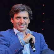 Carlos Sainz, ilusionado en la presentación del GP de 'Madring' tras el alzado de la bandera de España más grande del país: "Podré competir a veinte minutos de casa"