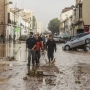 Varias personas recorren calles llenas de agua y barro tras el paso de la DANA por el barrio de La Torre de Valencia, a 30 de octubre de 2024. Rober Solsona / Europa Press