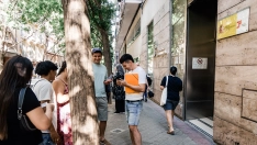 Varias personas migrantes esperan en el exterior de una oficina de la Seguridad Social.  Carlos Luján / Europa Press